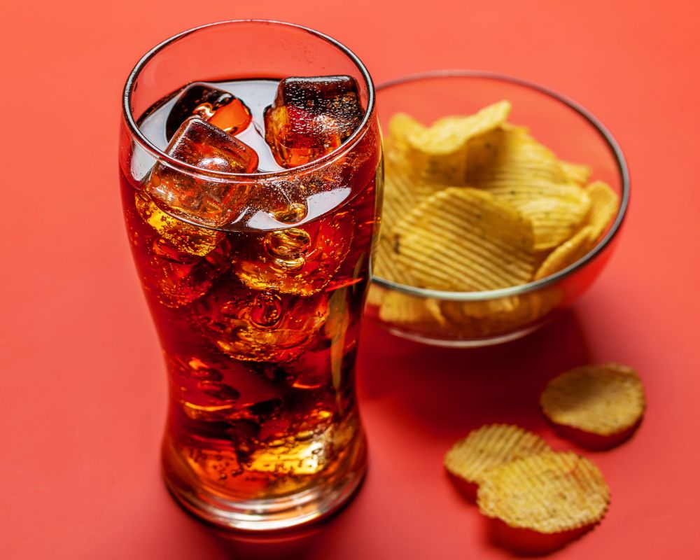 Refresco de cola con unas patatas fritas.